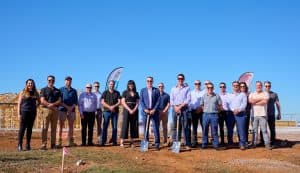A group of Henley Homes and Very Special Kids team members are standing outside where the new home will be built